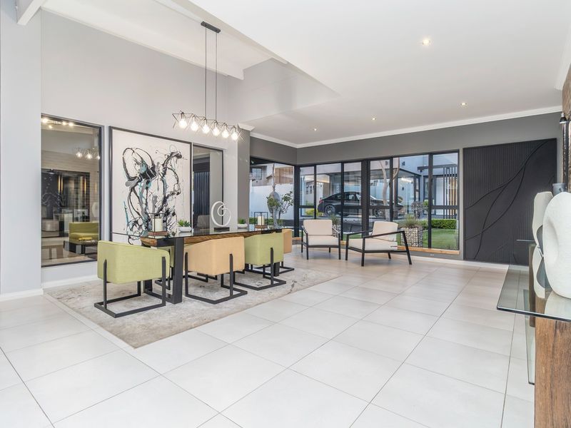 Spacious dining area featuring large glass sliding doors, tiled flooring, recessed lighting, and a striking exposed brick feature wall.