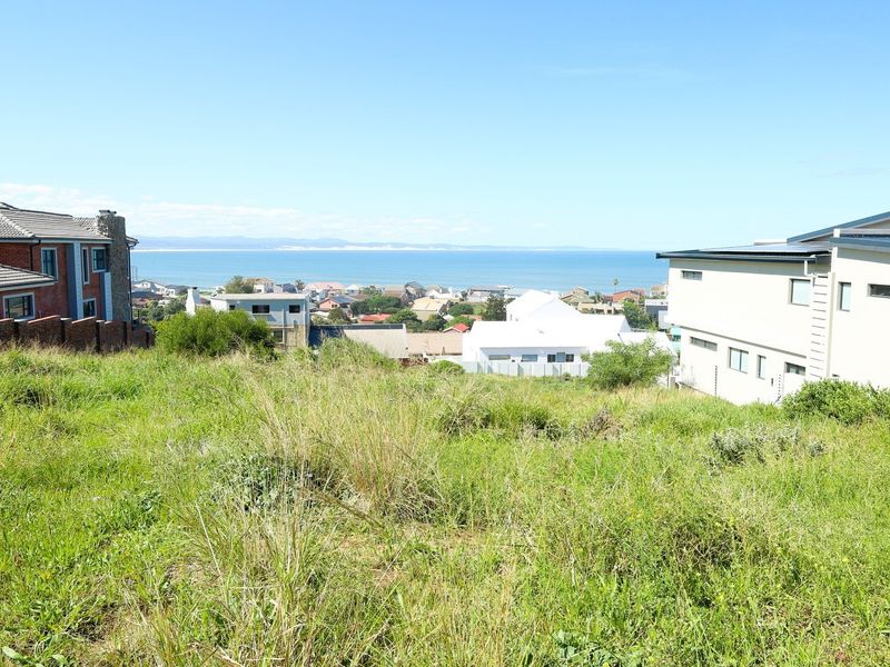 A vacant residential plot featuring a gentle slope and expansive views of the surrounding coastal neighbourhood and ocean.
