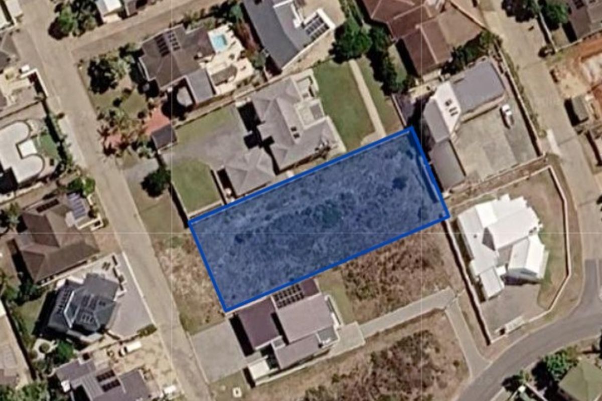 An aerial view of a vacant residential land plot situated within an established suburban neighborhood.