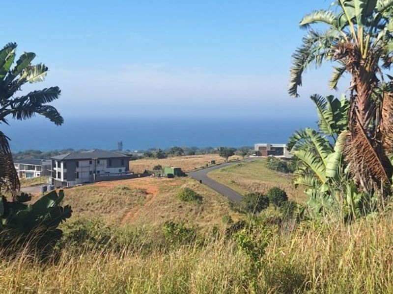 A scenic elevated view overlooking the coastal landscape and surrounding residential development from the vacant land plot.