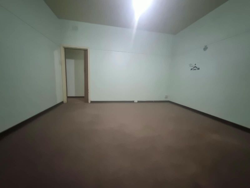 An empty bedroom featuring carpet flooring and neutral walls, providing a blank canvas for potential interior design updates.