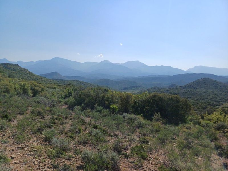 A scenic, expansive landscape view showcasing the natural mountainous terrain and indigenous vegetation surrounding the property.