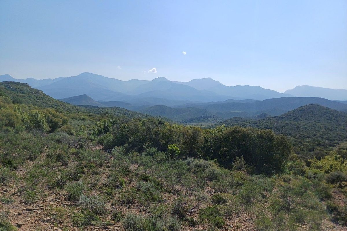 A scenic, expansive landscape view showcasing the natural mountainous terrain and indigenous vegetation surrounding the property.