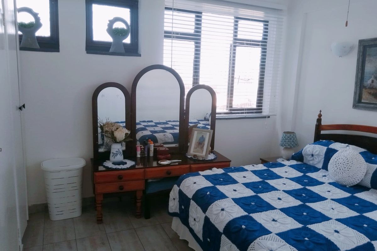 A bedroom featuring tiled flooring, venetian blinds, and natural light from multiple windows.