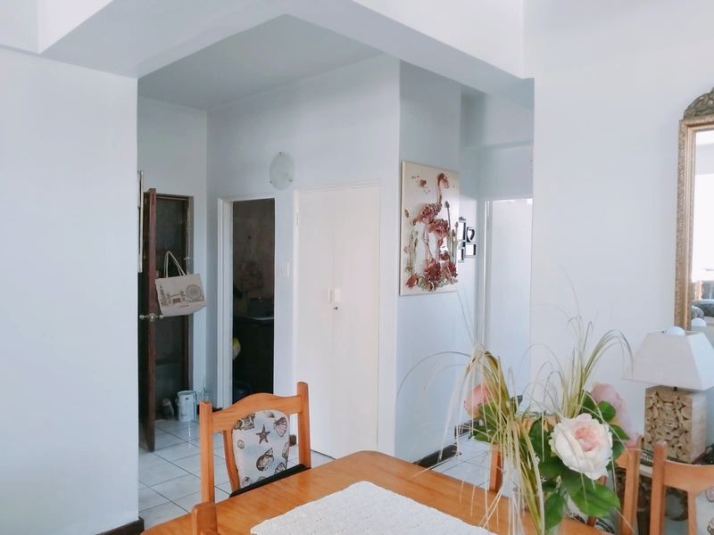 A functional hallway area featuring tiled flooring and built-in cupboard storage, providing access to adjacent rooms within the apartment.