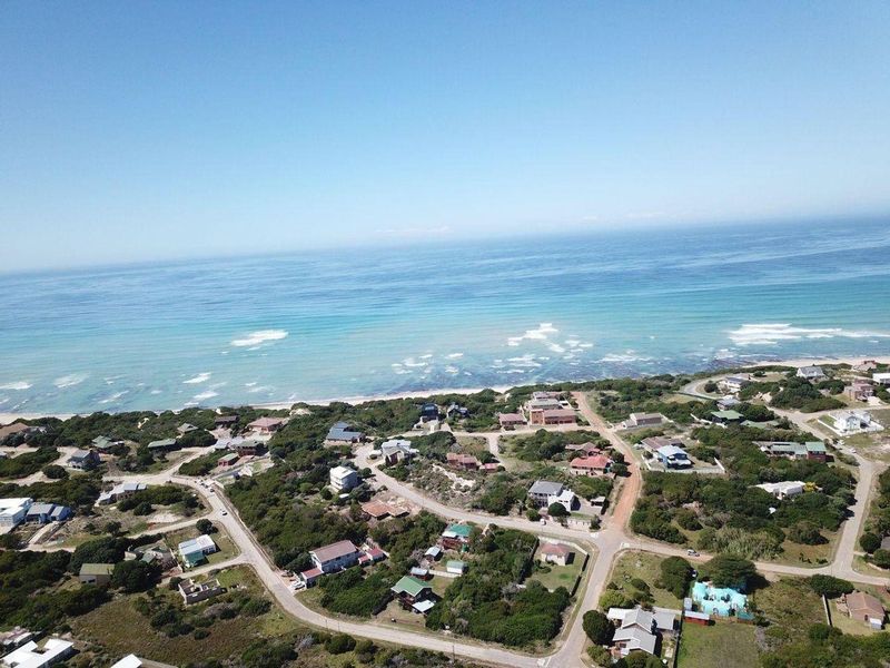 An aerial view of a coastal residential area, showcasing the proximity of the properties to the ocean and surrounding natural landscape.