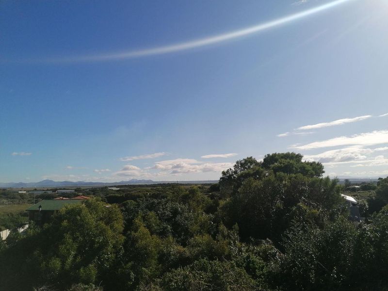 A scenic landscape view overlooking natural vegetation and distant hills, showcasing the surrounding environment of the vacant land.