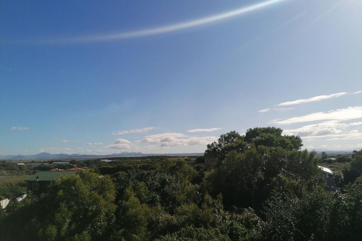 A scenic landscape view overlooking natural vegetation and distant hills, showcasing the surrounding environment of the vacant land.
