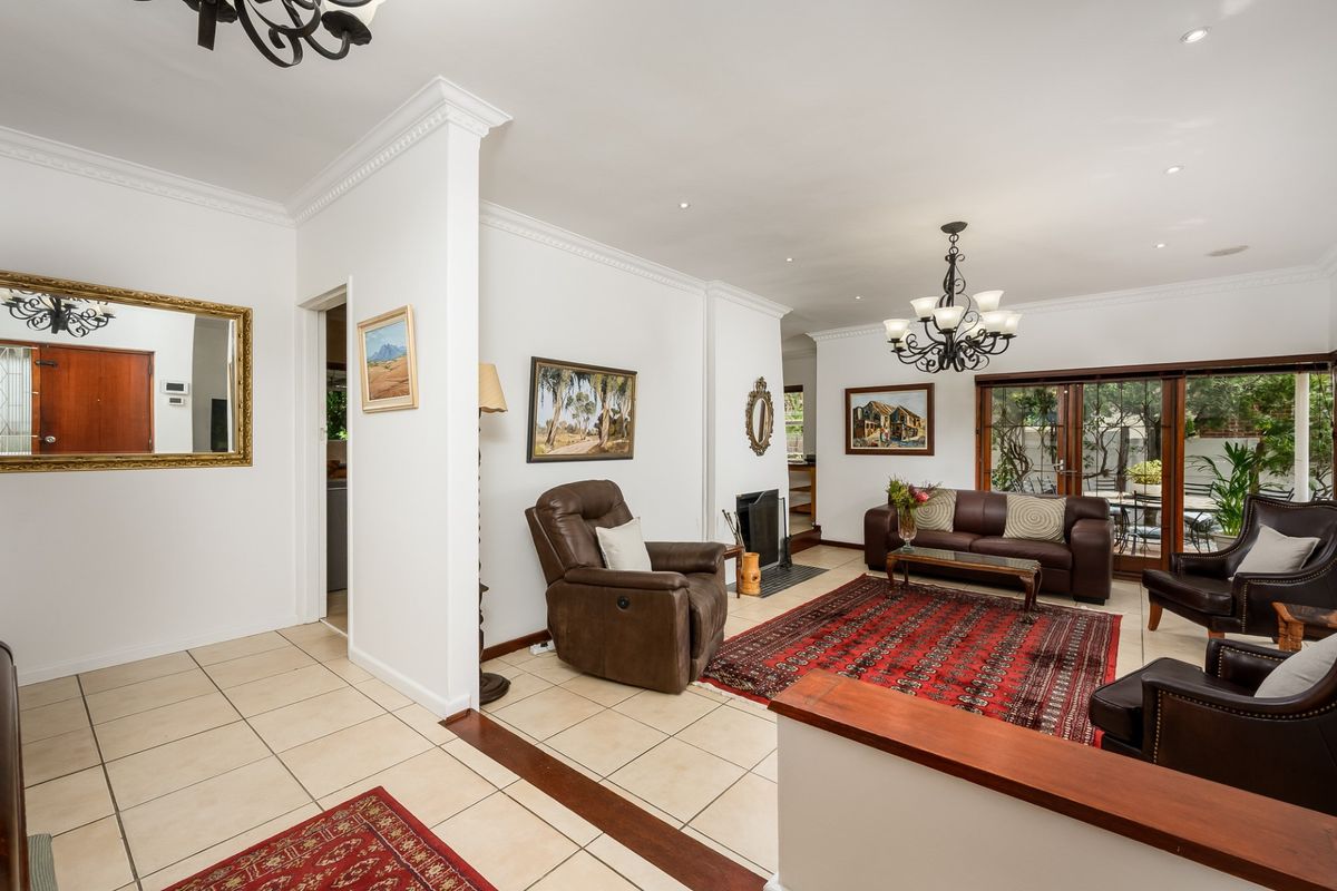 Spacious living room featuring tiled flooring, a fireplace, crown molding, and large sliding glass doors providing access to the outdoor area.