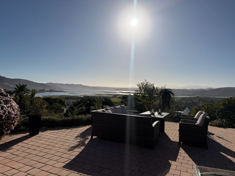 An outdoor paved patio area offering expansive scenic views of the surrounding landscape and estuary.