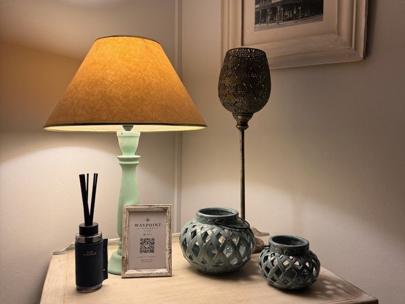A close-up view of a bedside table with decorative lighting and accessories.