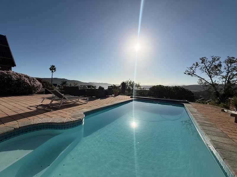 Outdoor swimming pool area featuring a tiled patio and scenic landscape views, perfect for relaxation and outdoor entertainment.