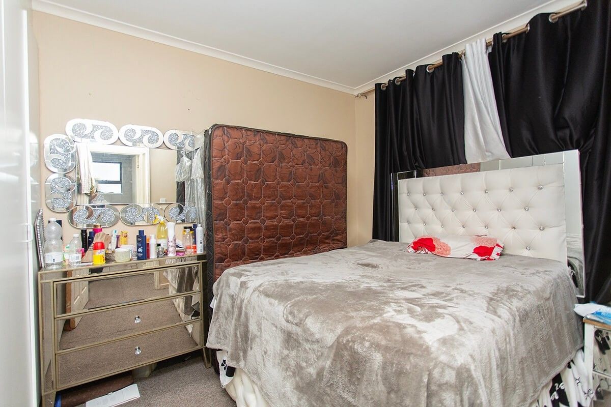 A standard bedroom featuring neutral wall finishes and coving, providing a functional space for rest.
