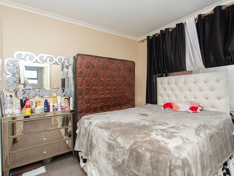 A standard bedroom featuring neutral wall finishes and coving, providing a functional space for rest.