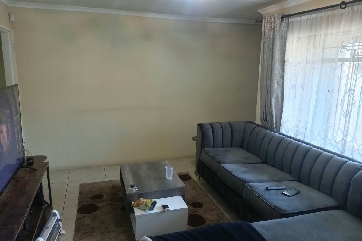A living room featuring tiled flooring and coved ceilings, offering a functional space ready for cosmetic updates and personalization.