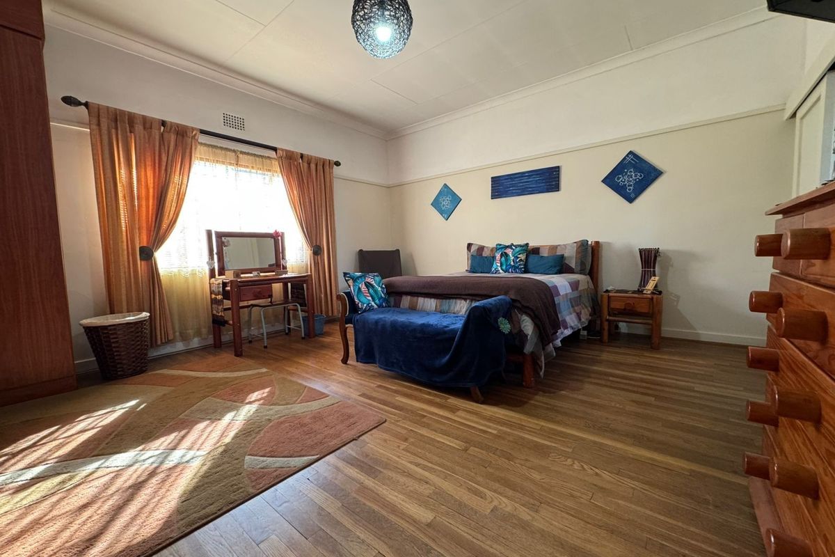 Spacious bedroom featuring laminate flooring, coved ceilings, and a built-in wardrobe, offering a comfortable and functional living space.