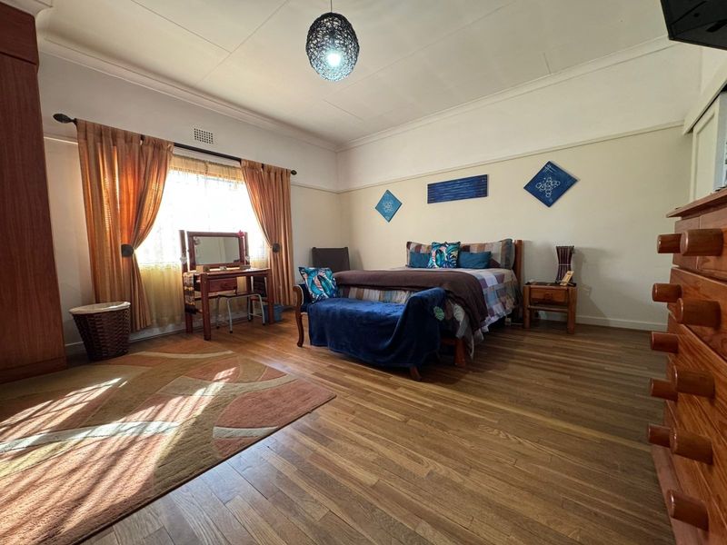 Spacious bedroom featuring laminate flooring, coved ceilings, and a built-in wardrobe, offering a comfortable and functional living space.