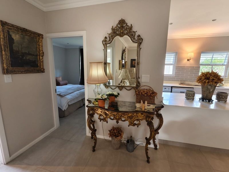 A well-maintained hallway area featuring tiled flooring and coved ceilings, providing a transition between the living space and the adjacent bedroom and kitchen.