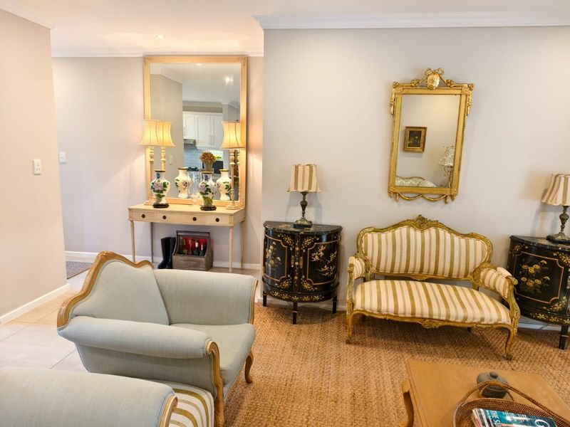 A well-maintained living area featuring neutral wall tones, decorative coving, and tiled flooring, providing a bright and inviting space.