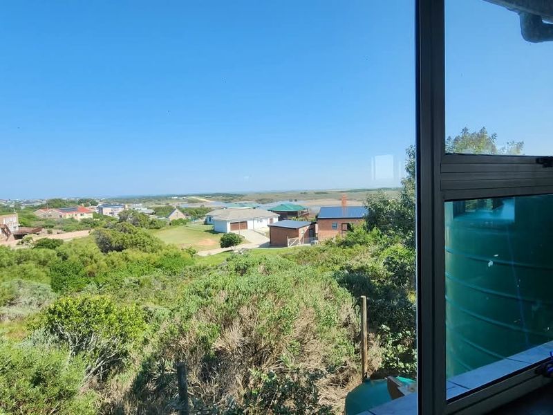 A scenic elevated view overlooking the surrounding neighbourhood and natural landscape, captured through a modern aluminium window frame.