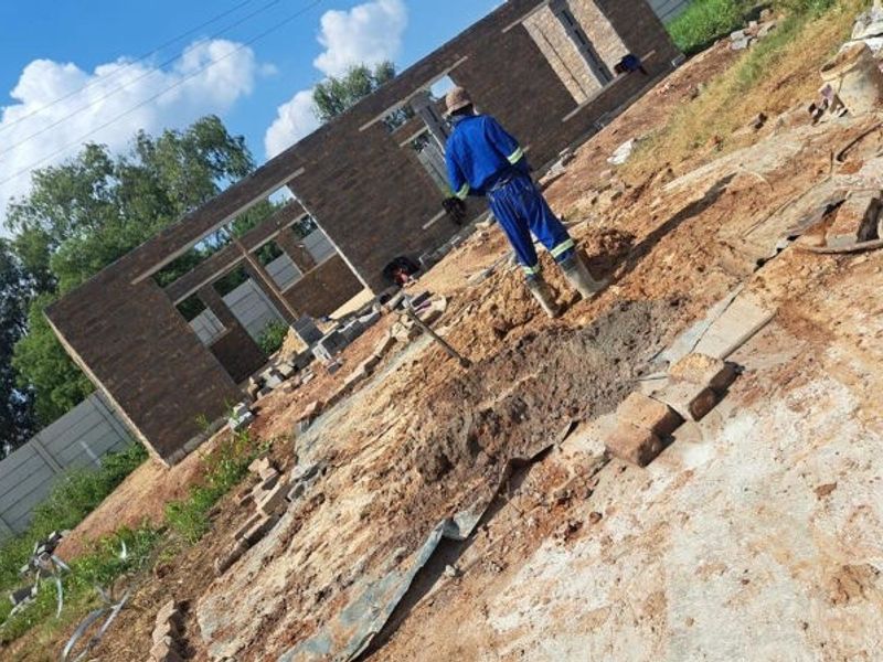 A construction site showing the early stages of building with face brick walling and an unlandscaped yard.