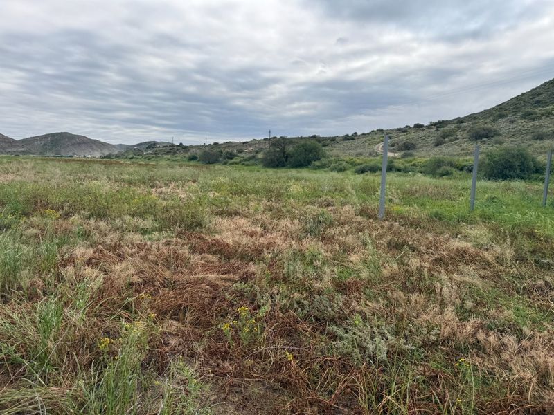 Expansive undeveloped land area featuring natural vegetation, open terrain, and distant mountain views, suitable for agricultural or small holding development.