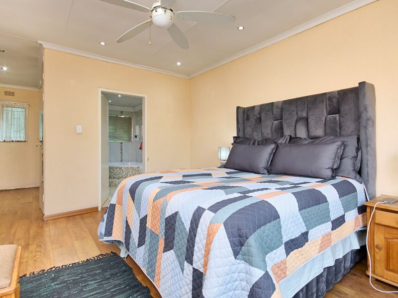 A bedroom featuring laminate flooring, a ceiling fan, and recessed lighting, with direct access to an en-suite bathroom.