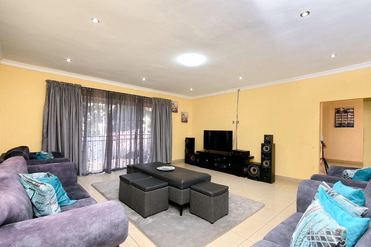 Spacious living room featuring tiled flooring, recessed downlighting, and a sliding glass door providing access to the exterior.