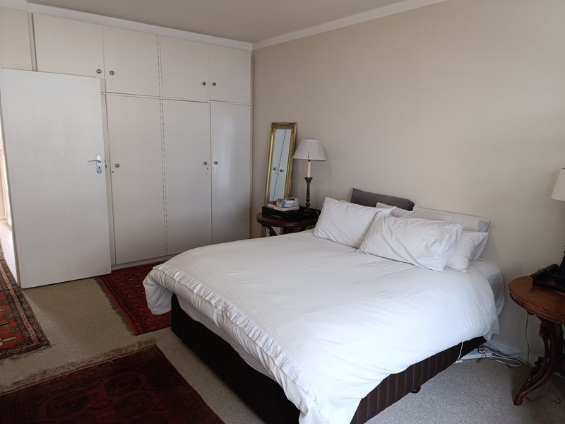 A bedroom featuring neutral walls, carpeted flooring, and ample built-in cupboard storage space.