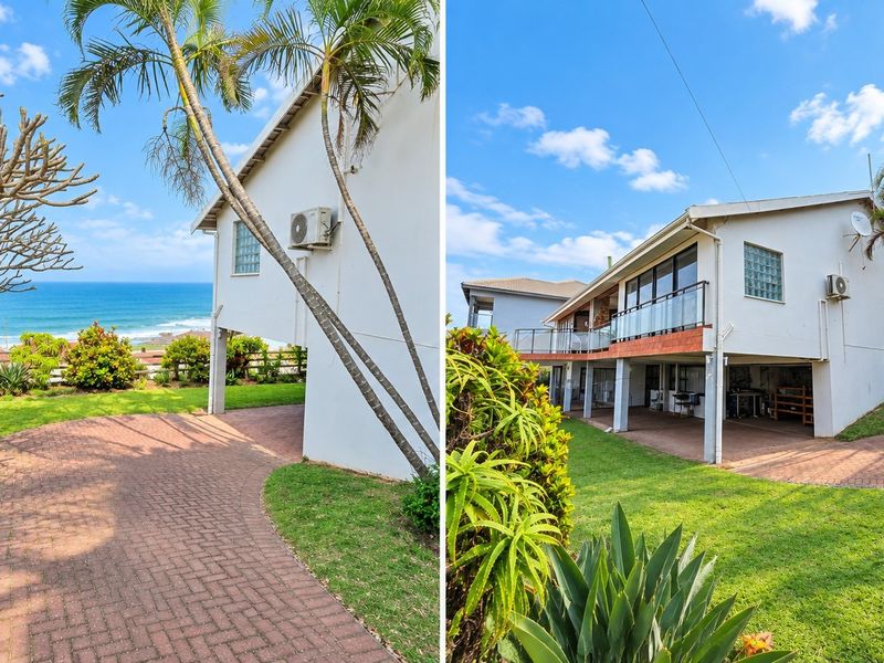 Rear exterior view of the property featuring a paved driveway, raised deck with glass balustrade, and ocean views.
