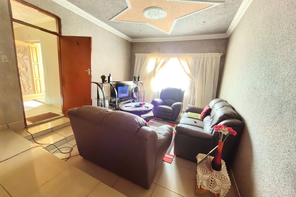 A living room featuring tiled flooring and a decorative star-shaped ceiling feature with molding.