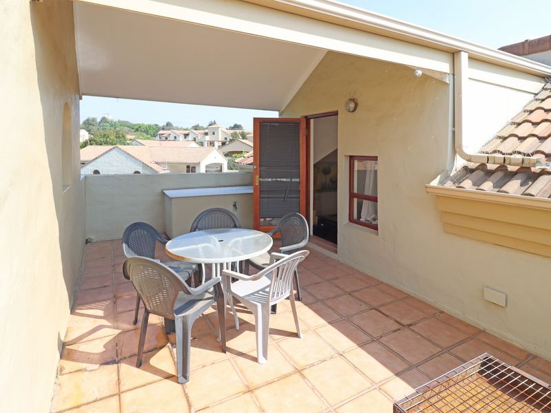 A covered balcony area featuring tiled flooring and direct access to the interior, providing a functional outdoor space for relaxation.