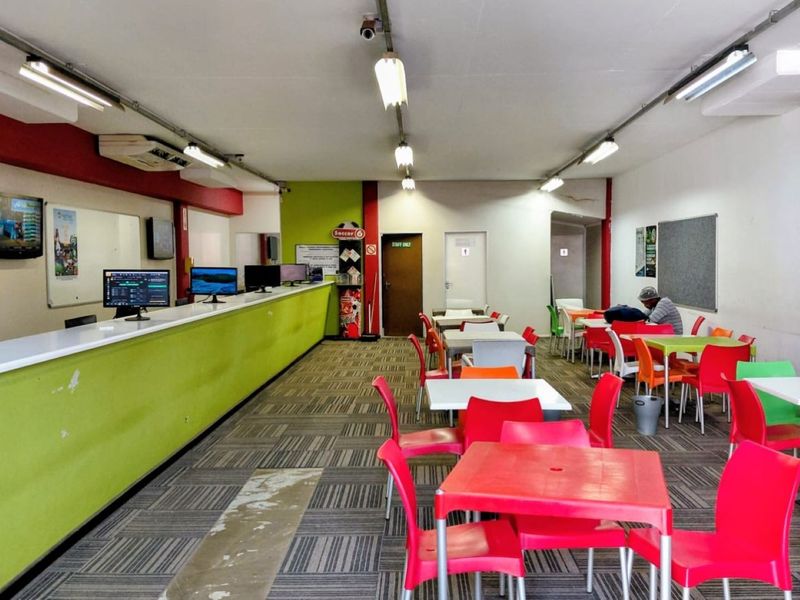 Open-plan commercial service area featuring a long service counter, fluorescent lighting, and carpeted flooring, suitable for a betting shop or customer service facility.