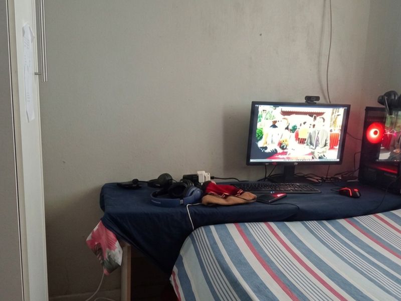 A bedroom featuring a built-in wardrobe and space for a desk setup, providing a functional layout for a sleeping and study area.