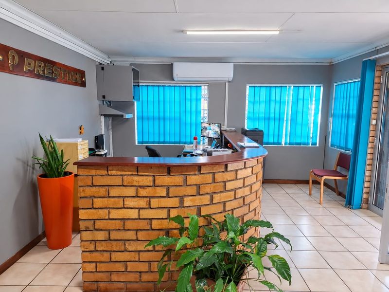 Commercial reception area featuring a brick-fronted service counter, tiled flooring, and wall-mounted air conditioning unit.