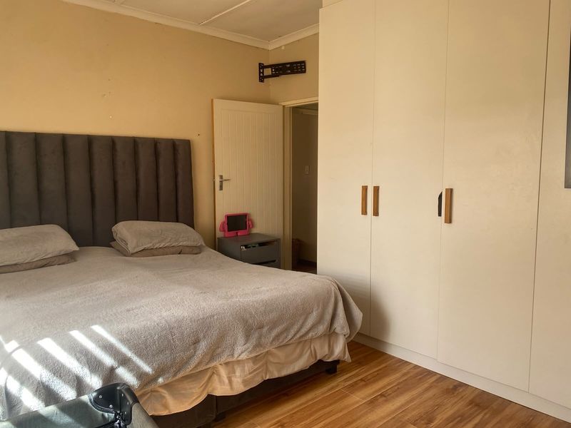 A bedroom featuring laminate flooring and built-in cupboards, providing functional storage space.