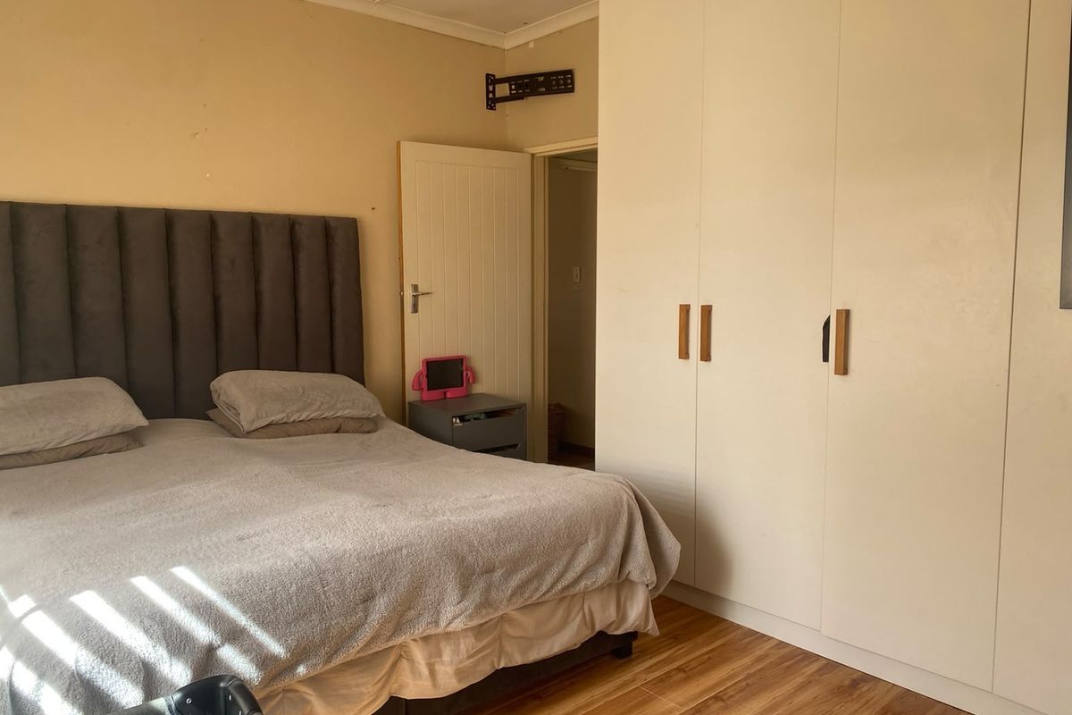 A bedroom featuring laminate flooring and built-in cupboards, providing functional storage space.