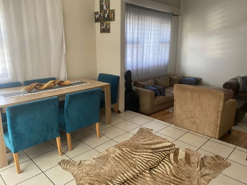 Open plan living and dining area featuring a combination of tiled and laminate flooring with neutral wall finishes.