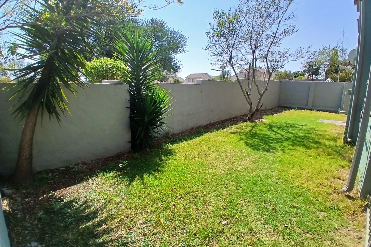 A private rear garden area featuring a well-defined boundary wall and established lawn space, suitable for outdoor recreation.