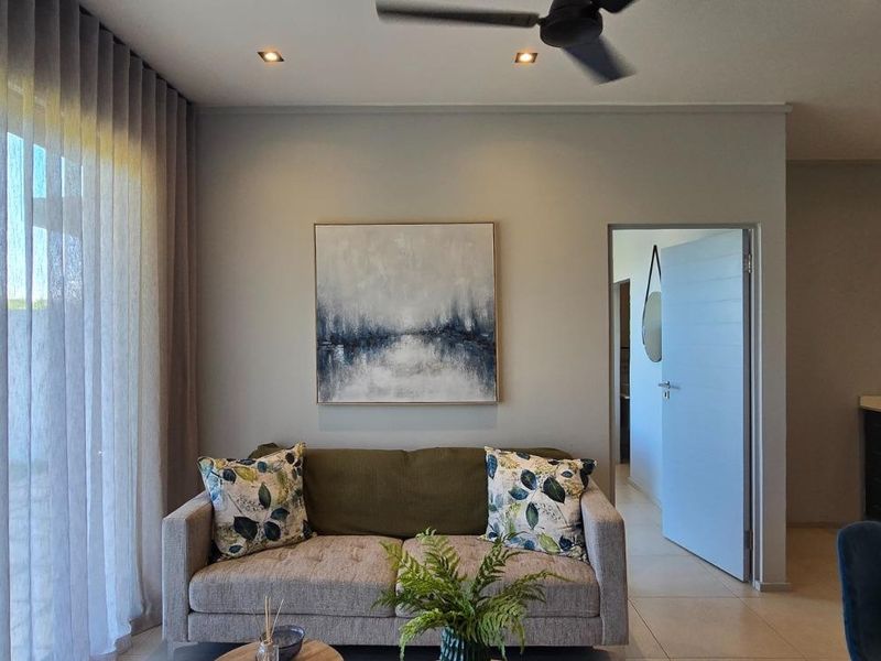 Modern open-plan living area featuring tiled floors, recessed lighting, a ceiling fan, and direct access to an outdoor space through sliding glass doors.