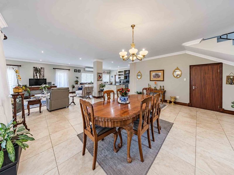 Spacious open-plan living and dining area featuring neutral tiled flooring, recessed lighting, and a seamless flow into the kitchen space.