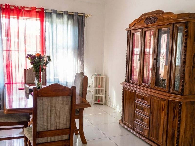 A dining room featuring tiled flooring and natural light from a large window.