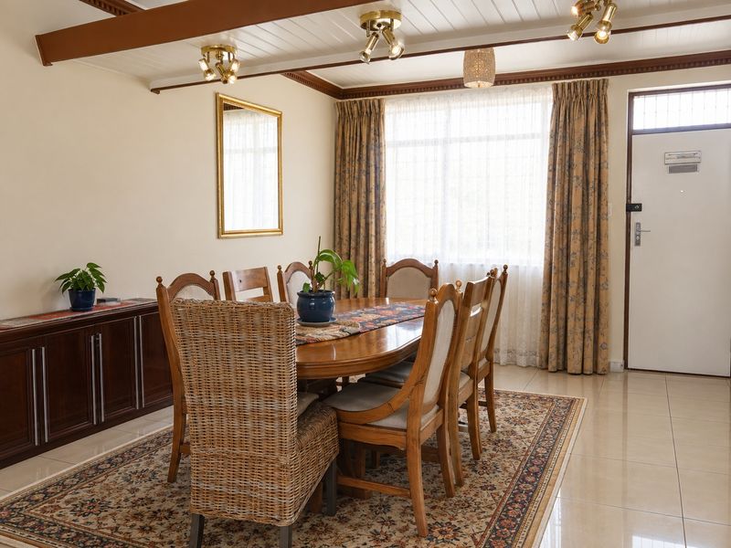 A dining room featuring tiled flooring, exposed ceiling beams, and built-in cabinetry, offering a functional space for family meals.