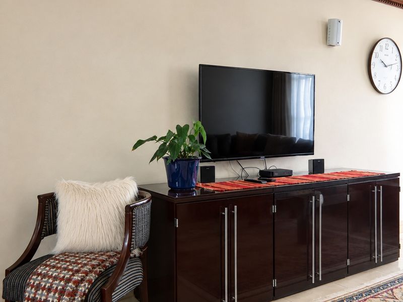 A well-maintained living room area featuring crown molding and tiled flooring, providing a clean and neutral backdrop for the space.