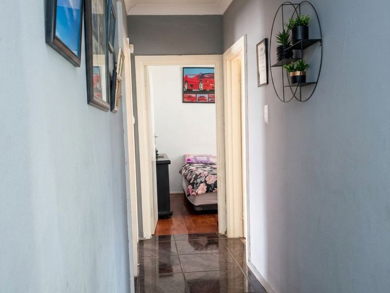 A functional hallway featuring tiled flooring and neutral wall finishes, providing access to adjacent rooms within the home.