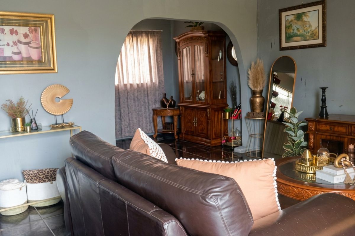 A living room featuring an arched doorway leading to an adjacent space, finished with dark tiled flooring.