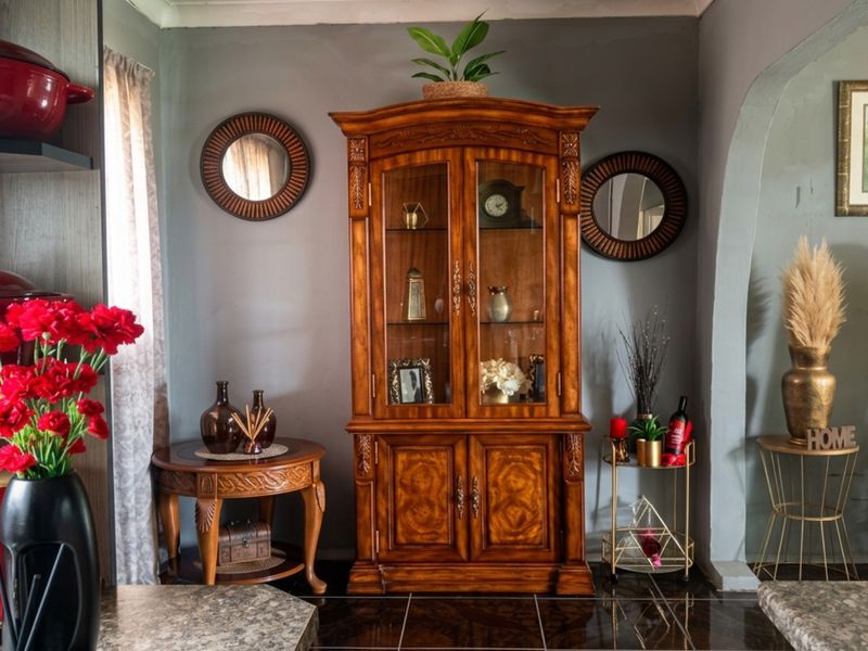 A well-maintained kitchen area featuring dark tiled flooring, a decorative archway, and built-in shelving, creating a warm and inviting atmosphere.