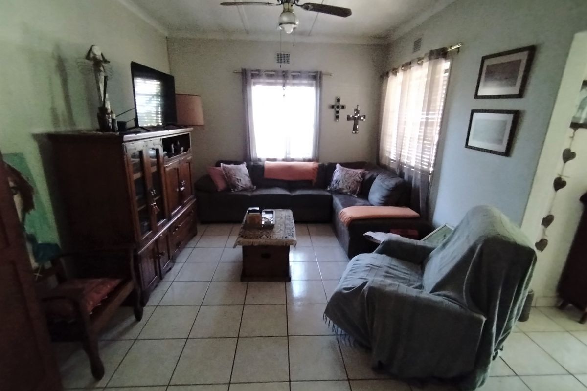 A living room featuring ceramic floor tiles, a ceiling fan, and neutral wall finishes, providing a functional and comfortable space for relaxation.