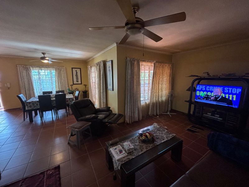 Spacious open-plan living and dining area featuring tiled flooring and ceiling fans, providing a functional layout for family living.