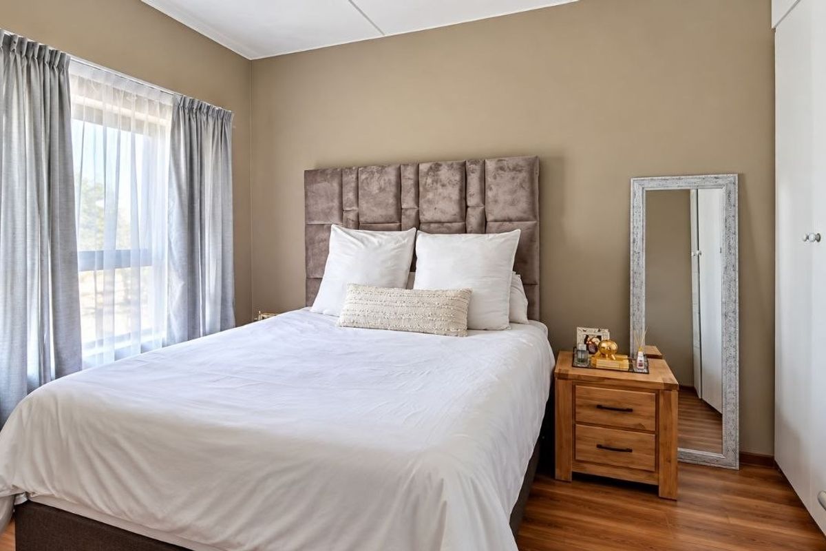 A well-maintained bedroom featuring laminate flooring, neutral wall tones, and a built-in wardrobe, offering a clean and comfortable living space.